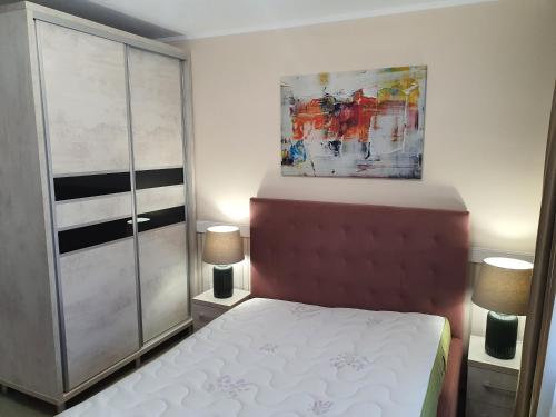 1 dormitorio con 1 cama y una pintura en la pared en Sunrise Home Apartment en Mangalia
