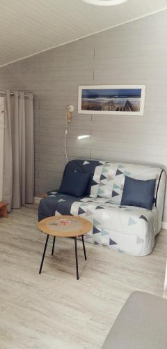 a living room with a bed and a coffee table at Chambre d'hôtes sur les plages du débarquement in Ver-sur-Mer