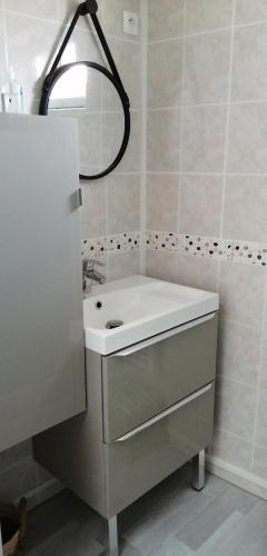 ein Badezimmer mit einem weißen Waschbecken und einem Spiegel in der Unterkunft Chambre d'hôtes sur les plages du débarquement in Ver-sur-Mer