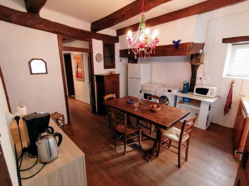 uma cozinha e sala de jantar com uma mesa de madeira em 11 rue basse Najac em Najac