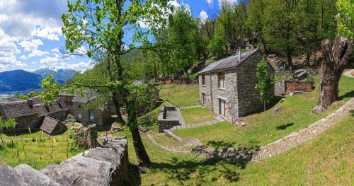 une ancienne maison en pierre sur le côté d'une colline dans l'établissement Birdbox Curzútt, à Monte Carasso