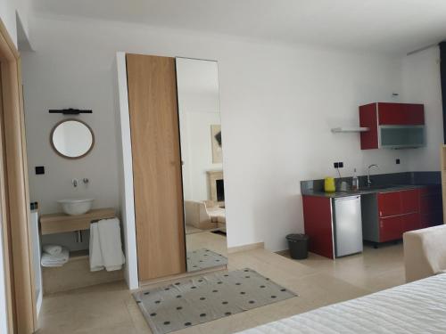a room with a bathroom with a sink and a mirror at Enalion residences in Tinos