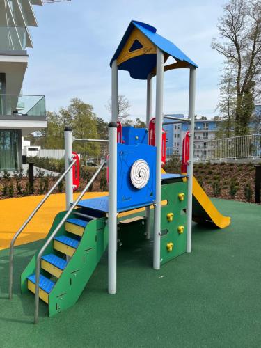 a playground with a slide and stairs on a playground at Apartament Morski Widok Międzyzdroje in Międzyzdroje