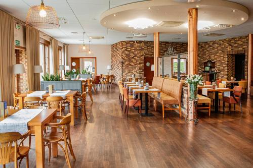 restauracja ze stołami i krzesłami oraz ceglaną ścianą w obiekcie Hotel Spichlerz Lubawa w mieście Lubawa