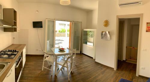 a kitchen with a table and a dining room at Appartamento Il Pomodoro in San Vito lo Capo