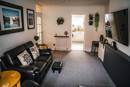 a living room with a leather couch and a television at Aunt Mary's in Belfast