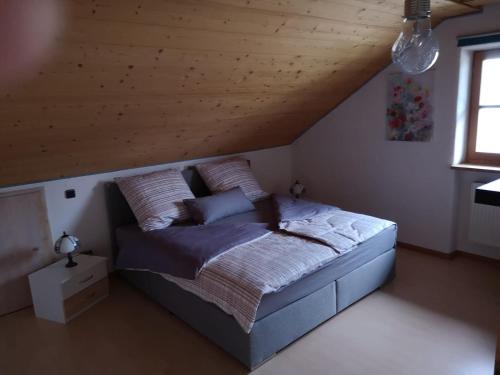 Bett in einem Schlafzimmer mit Holzdecke in der Unterkunft Antonia in Egling