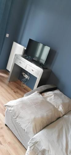 a bedroom with a bed and a desk with a television at Apartament centrum Dworzec in Białystok