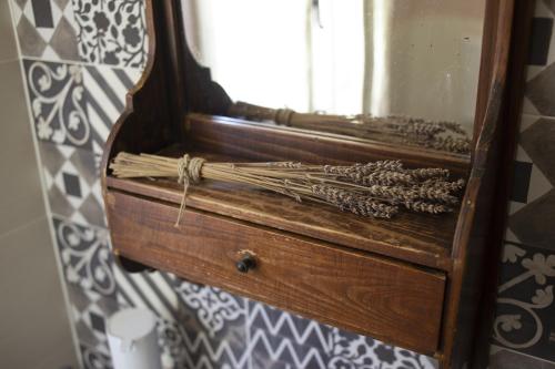a wooden dresser with a mirror and some branches at B&B Agriturismo Casa Vallona in Monte San Pietro