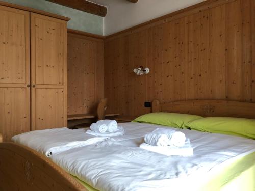a large bed with two towels on top of it at B&B Monte Tesobo in Roncegno