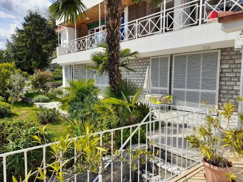 ein Haus mit einer Palme davor in der Unterkunft Apartments Kiki in Opatija