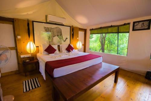 een slaapkamer met een bed en een groot raam bij Yala Leopard Mobile Camp in Yala