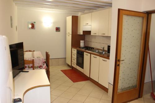 kuchnia z białymi szafkami i kuchenką w obiekcie CHIARA HOUSE VENICE w Wenecji