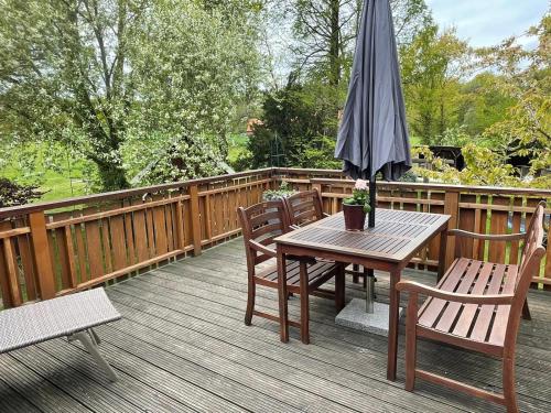 a wooden deck with a table and an umbrella at Ferienwohnung Varus in Ostercappeln