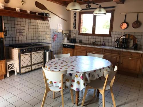 a kitchen with a table and chairs in it at Maison Marie Port in Pendé