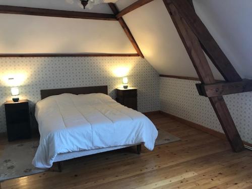 a bedroom with a white bed and two night stands at Maison Marie Port in Pendé