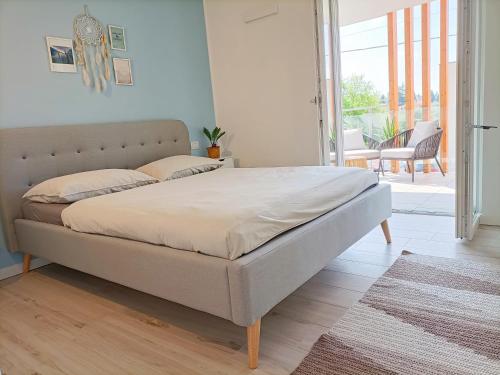 a large bed in a bedroom with a balcony at Lake Dream Apartment with Pool in Bardolino in Bardolino