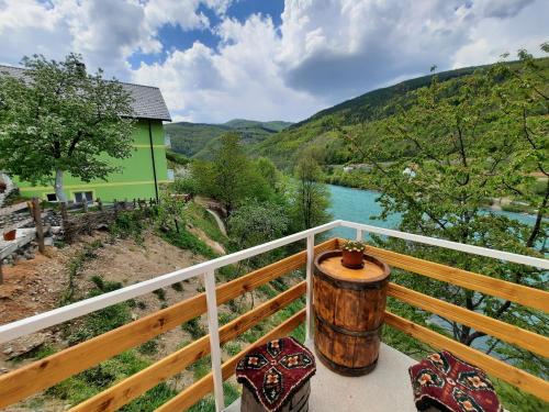 a barrel on a balcony with a view of a river at Apartmani Vila na Drini in Foča