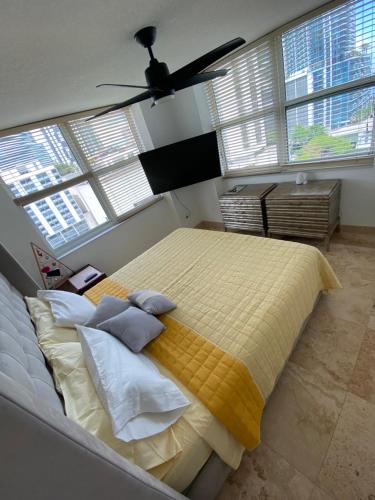 a bedroom with a large bed with a yellow blanket at Comfortable room in the Brickell City Center area in Miami