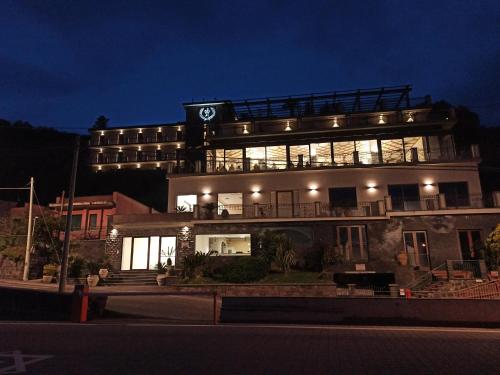 a building with a clock on top of it at night at Hotel Primavera Dell'Etna in Zafferana Etnea