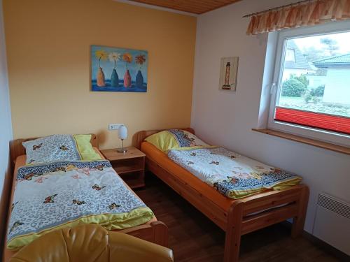 two twin beds in a room with a window at FEWO Borchert in Cuxhaven
