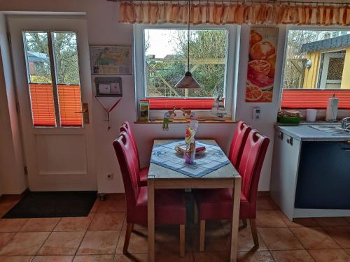 a kitchen with a table with red chairs and a table at FEWO Borchert in Cuxhaven