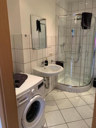 a bathroom with a shower and a washing machine at 1-Zimmer-Wohnung Astfeld in Langelsheim