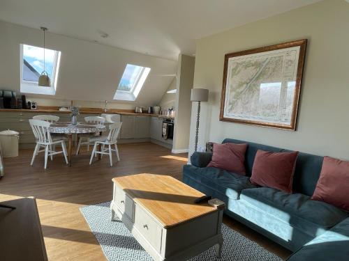 a living room with a blue couch and a table at Little Thistle Apartment in Whitebridge