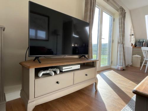 a television on top of a dresser in a living room at Little Thistle Apartment in Whitebridge