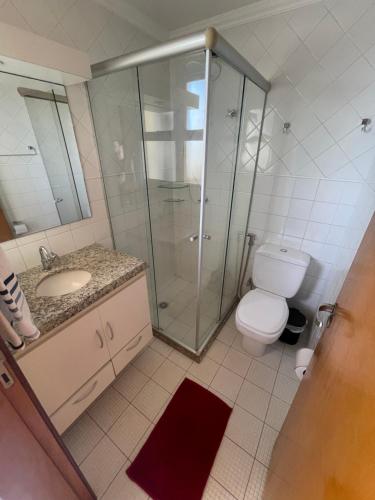 a bathroom with a shower and a toilet and a sink at The Belluno apartamento completo e aconchegante in Ribeirão Preto