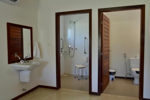 a bathroom with a shower and a sink and a mirror at PAUSA Hotel in Fortim