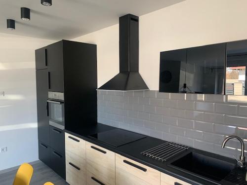 uma cozinha com balcões pretos e um fogão forno superior em New Home Guest House em Gödöllő