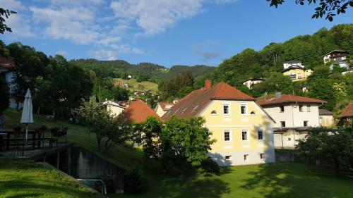 a large white house on a hill next to a village at Schlossapartments Wolfsberg in Wolfsberg