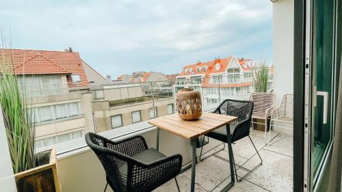 een tafel en stoelen op een balkon met uitzicht bij la MERéMOI - Duplex Knokke with balcony and free parking in Knokke-Heist