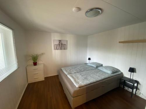 a bedroom with a bed and a dresser in it at Sukkertoppen Apartment in Ålesund