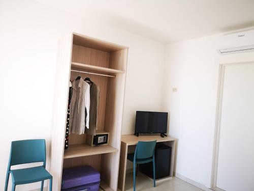 a room with two chairs and a desk and a television at Hotel Mare Blu in Torre dell'Orso