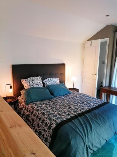 um quarto com uma cama grande e almofadas azuis em Le Garni Vendémiaire em Vesoul