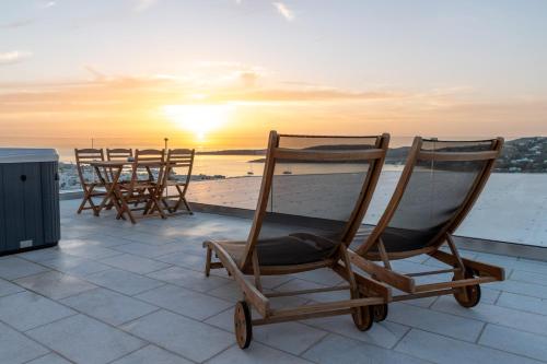 
a row of chairs sitting on top of a beach at Sunset View Hotel in Parikia
