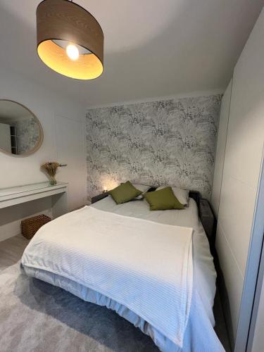 a bedroom with a large white bed with a light at Le MACA 1 in Le Cannet