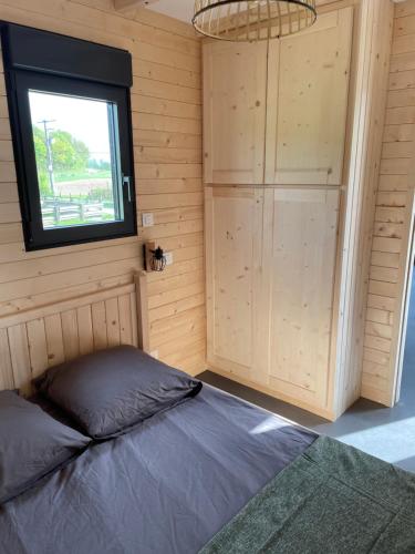 une chambre avec un lit et une fenêtre dans l'établissement Au cœur de la ferme 2, à Lacroix-sur-Meuse
