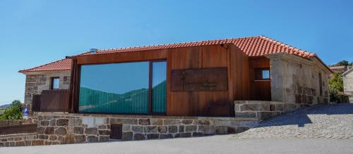 a building with a large window on the side of it at Charme da Mourela in Covelães