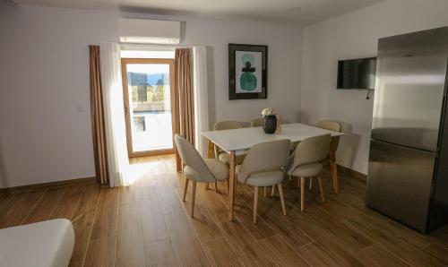 a kitchen with a table and chairs and a refrigerator at Charme da Mourela in Covelães