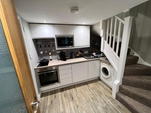 a small kitchen with a washer and dryer at The Tower, 1 bed 1850's Tiny House in Maldon
