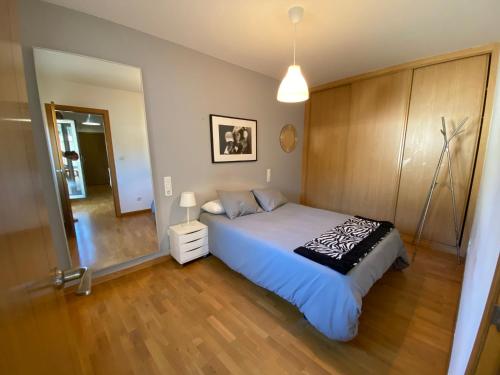 1 dormitorio con 1 cama grande y suelo de madera en Apartamento a 5 min caminando de la Playa Sta. Cristina, Oleiros (Terraza, Parkin, ), en Oleiros