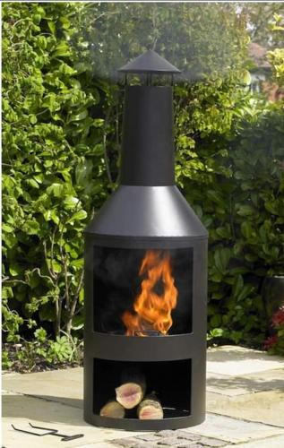 a black stove with a fire inside of it at The Bothy near Tenby, Big Projector Screen, Four-poster bed, on-site HOT TUB access via Spa Pack in Tenby