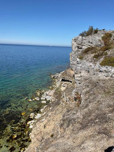 a rocky shoreline with the ocean behind it at Högklint by the Sea Apartment in Visby