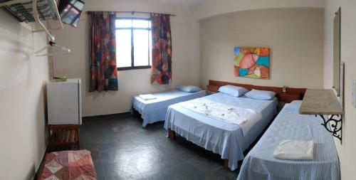 a bedroom with two beds and a window at Pousada de Ubu in Anchieta