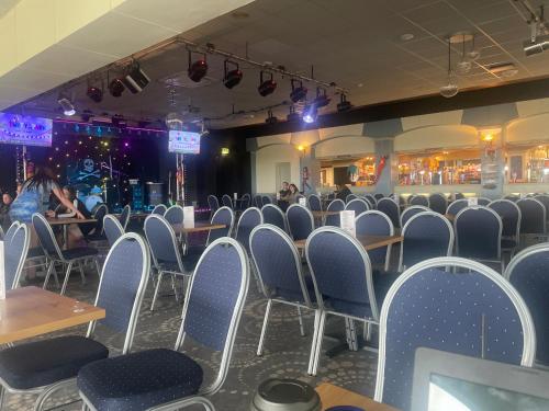 an empty room with chairs and tables and people in a restaurant at B23 in Goodrington