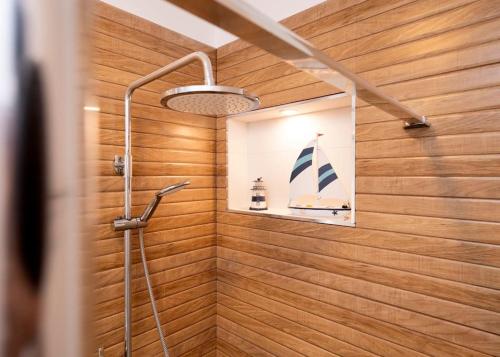 a bathroom with a shower with a picture of a boat on the wall at AWAKEN Gorgeous Sea View Apartment in Hvar