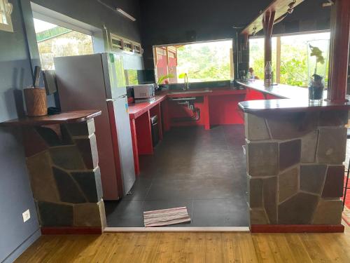 a kitchen with red cabinets and a refrigerator in it at petit_paradis_97120 in Saint-Claude